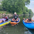 photo of group of paddlers napping on boards on water