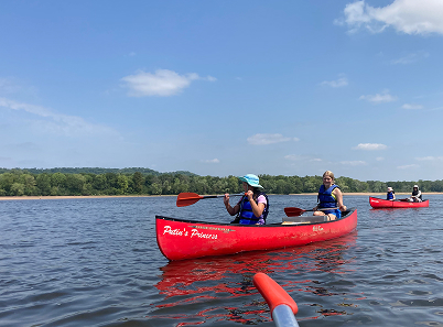 photo of people in two canoes on river